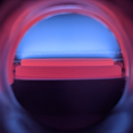 Neon-illuminated spherical chamber with red and blue glowing bands on dark background
